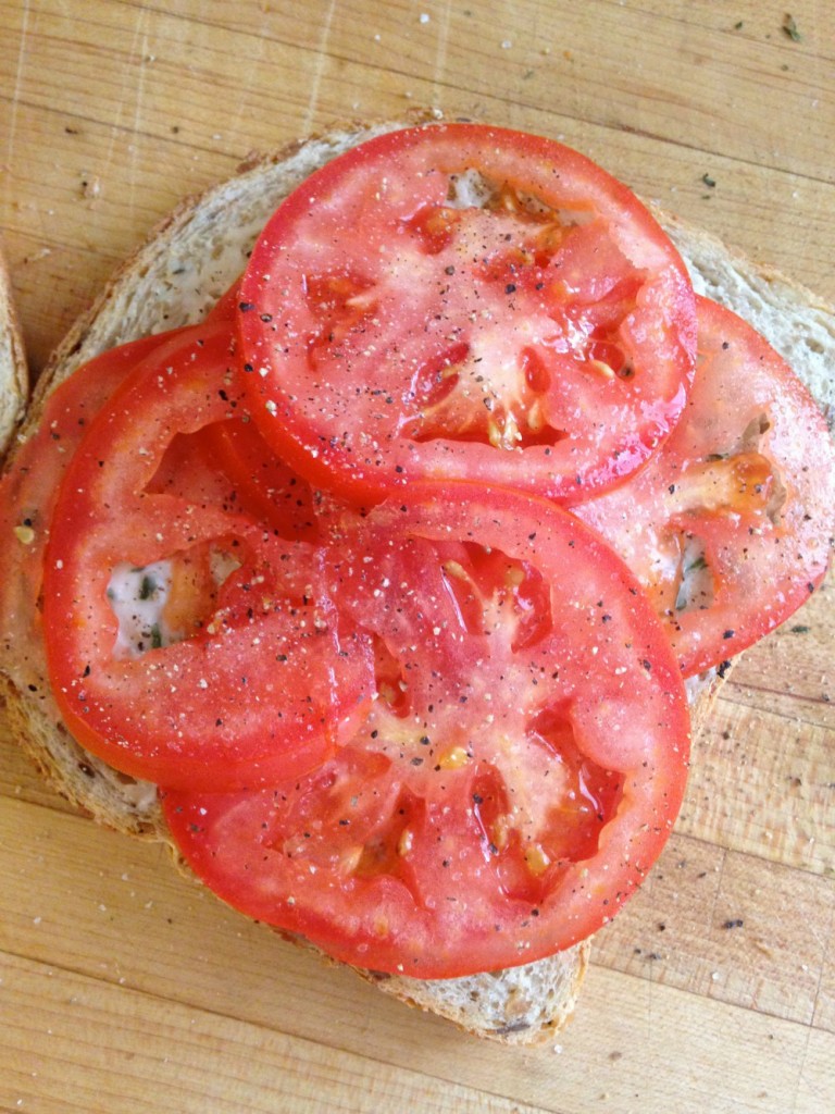 Sliced tomatoes on a piece of toasted bread.