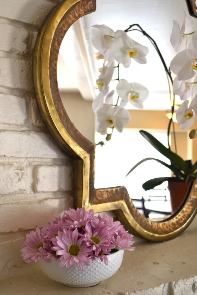 Mantel with mirror and orchid.