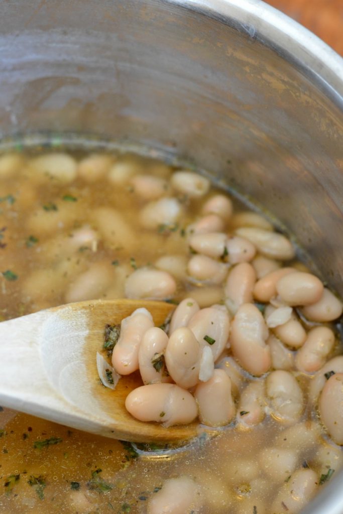 White beans simmering in a stainless steel pot