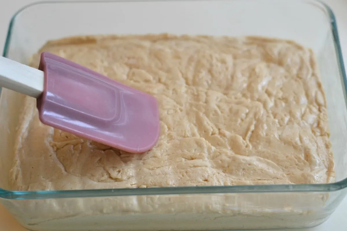 Spreading the fudge into a dish to cool