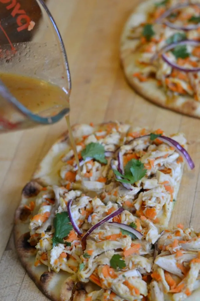 Peanut sauce drizzled over naan chicken satay pizza