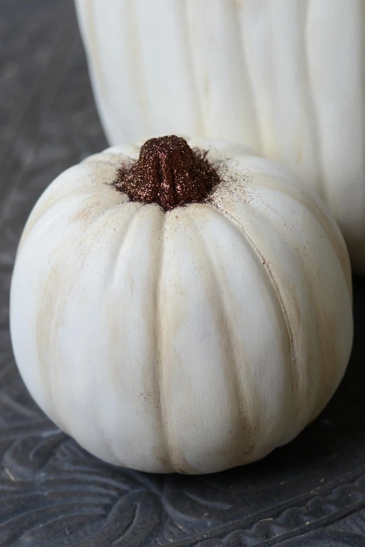 Painted craft pumpkin with a stem covered in glitter.