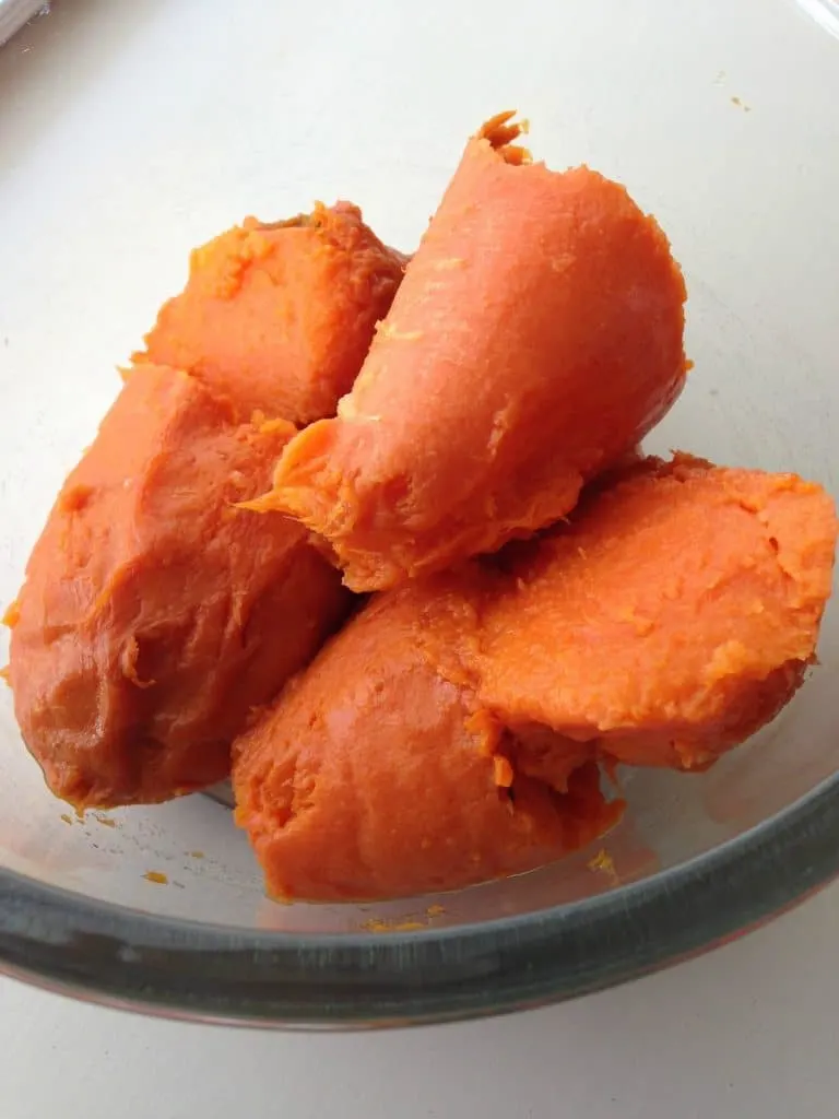 Peeled, baked sweet potatoes in a glass bowl