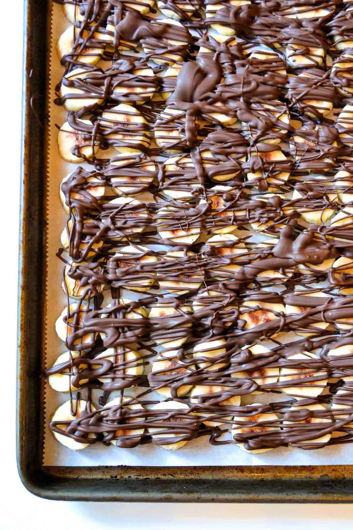 Tray of frozen bananas drizzled with chocolate