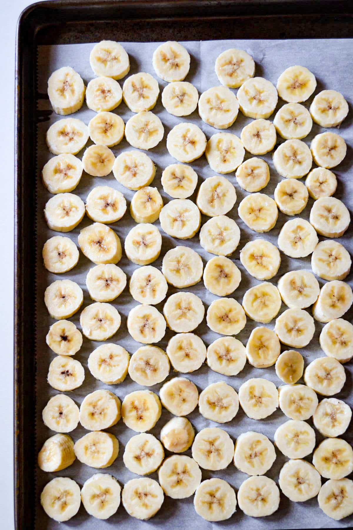 Sliced bananas frozen on a baking tray