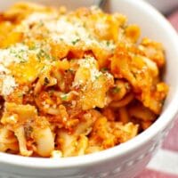 Close up of cheesy baked rotini in a bowl.