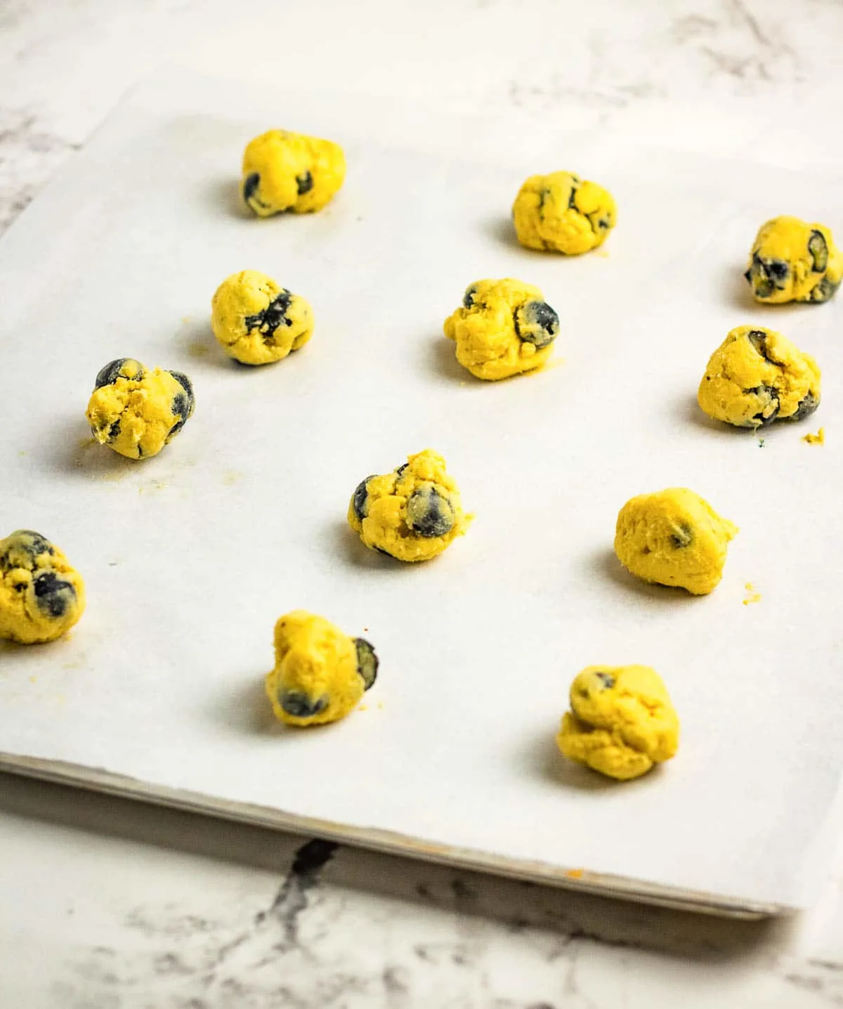 Lemon blueberry cookie dough balls scooped onto a baking sheet