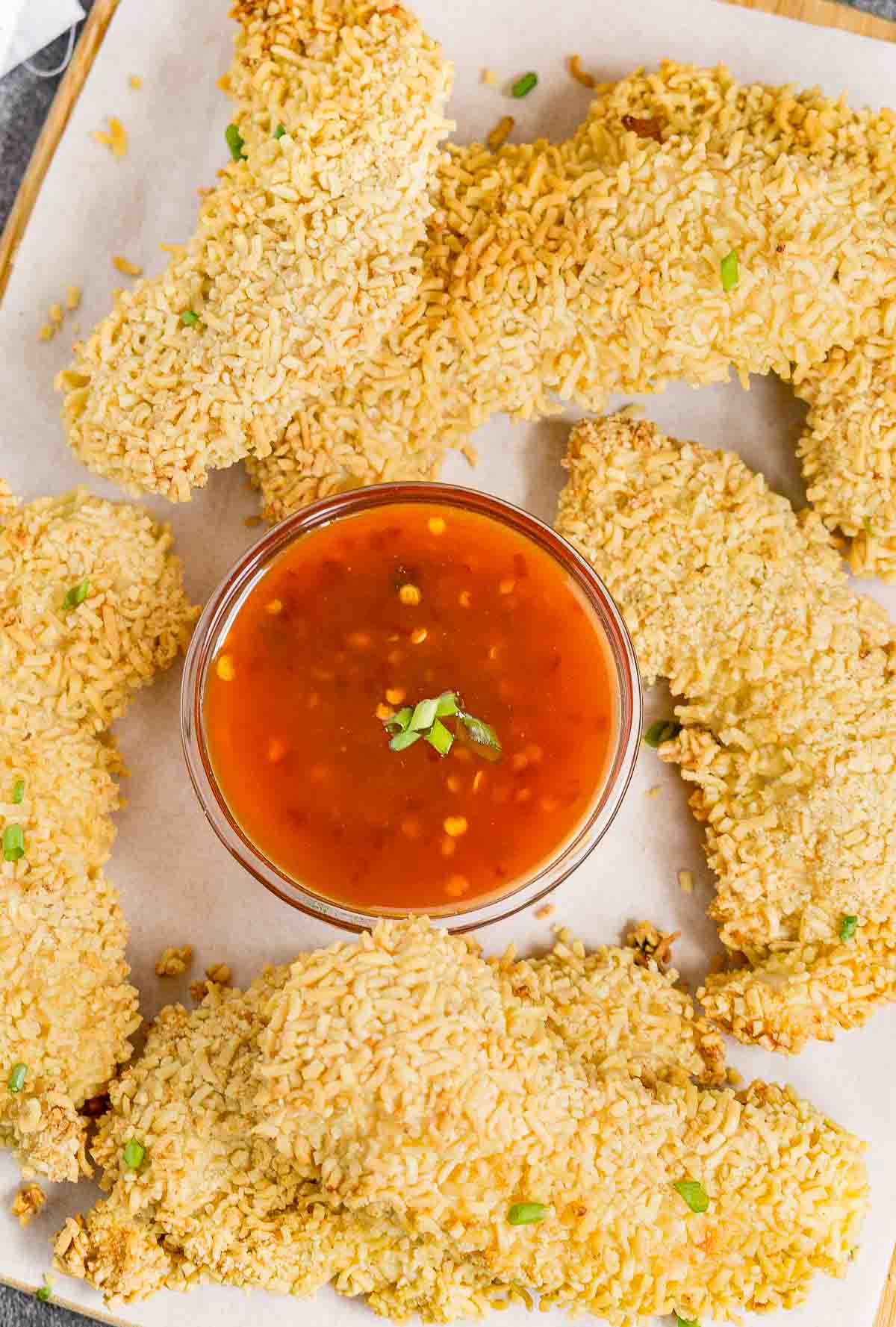 Ramen crusted chicken tenders on a serving platter with sauce