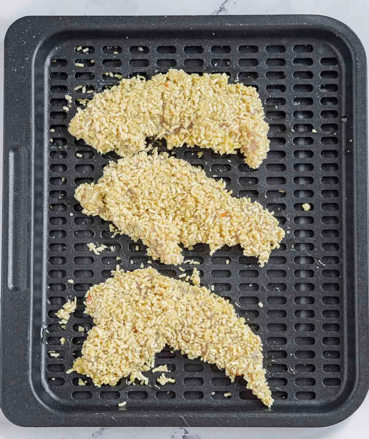 Ramen-coated chicken tenders on an air fryer tray