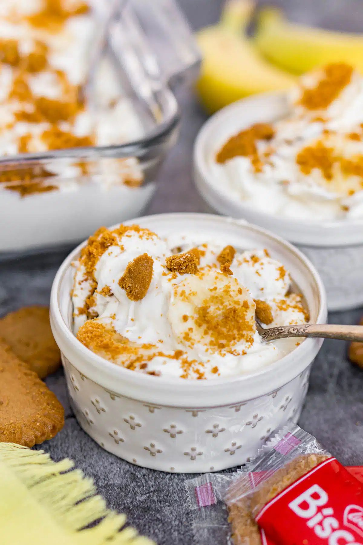 Bowl of Biscoff banana pudding topped with banana slices and Biscoff crumbs