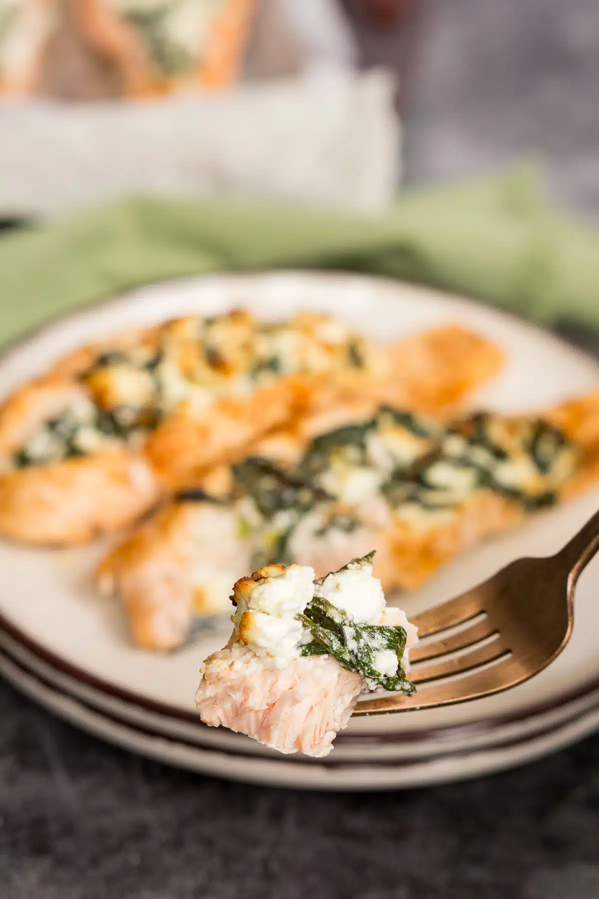 Fork with a piece of salmon with feta and spinach
