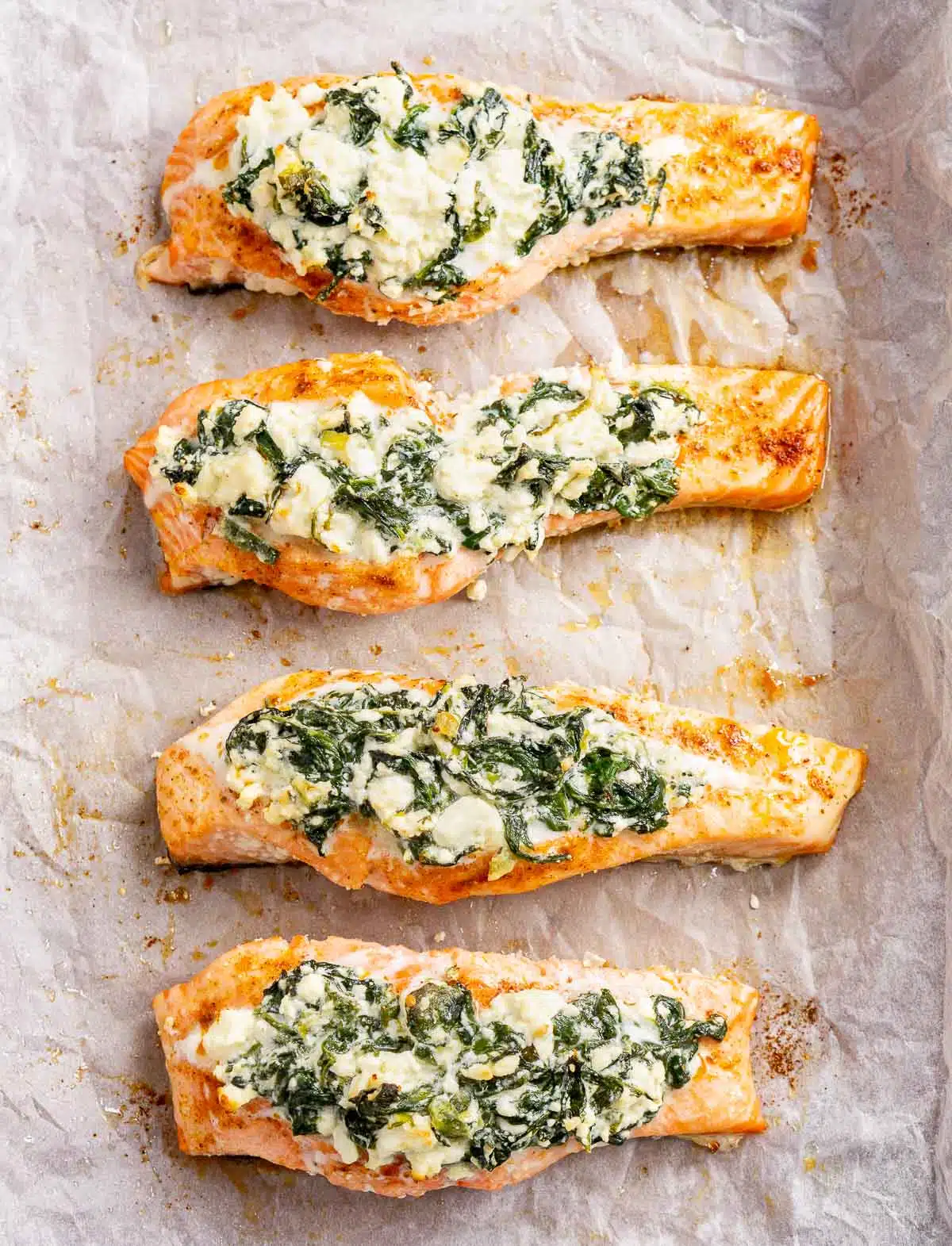 Baked salmon stuffed with feta and spinach on a baking sheet