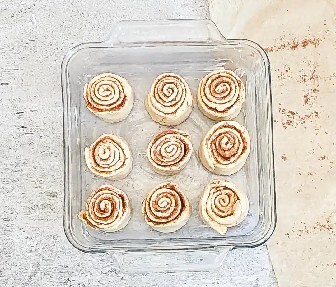 Crescent dough cinnamon rolls in prepared baking pan ready to bake