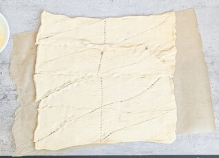 Two tubes of crescent dough laid out and pressed into 1 sheet of dough