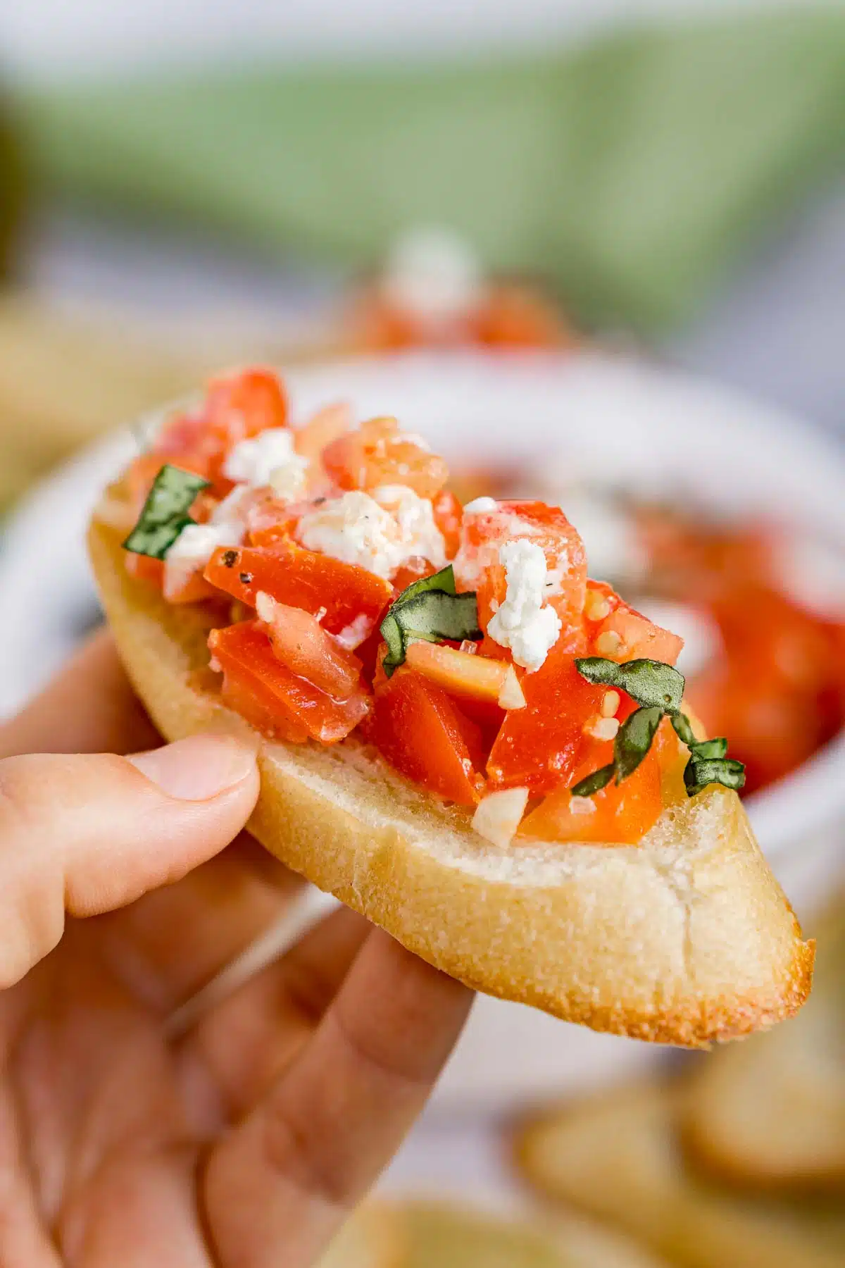 Hand holding goat cheese bruschetta appetizer