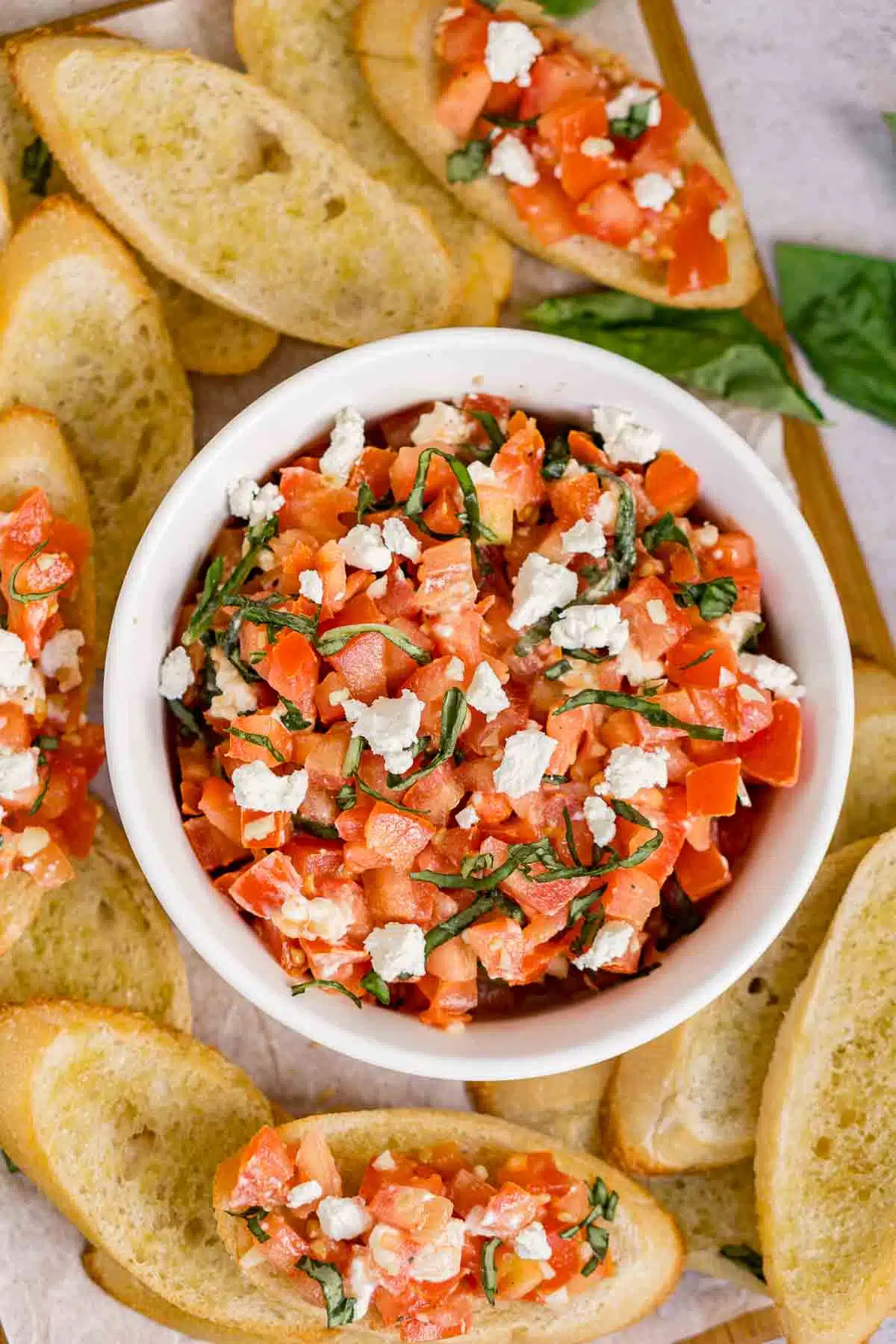 Bowl of goat cheese bruschetta on a serving board