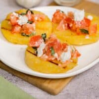 Grilled polenta appetizer topped with bruschetta