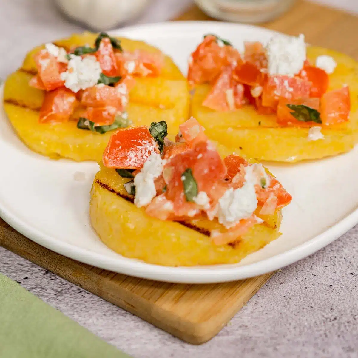 Grilled polenta appetizer topped with bruschetta