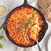 Skillet of baked cheesy pizza beans