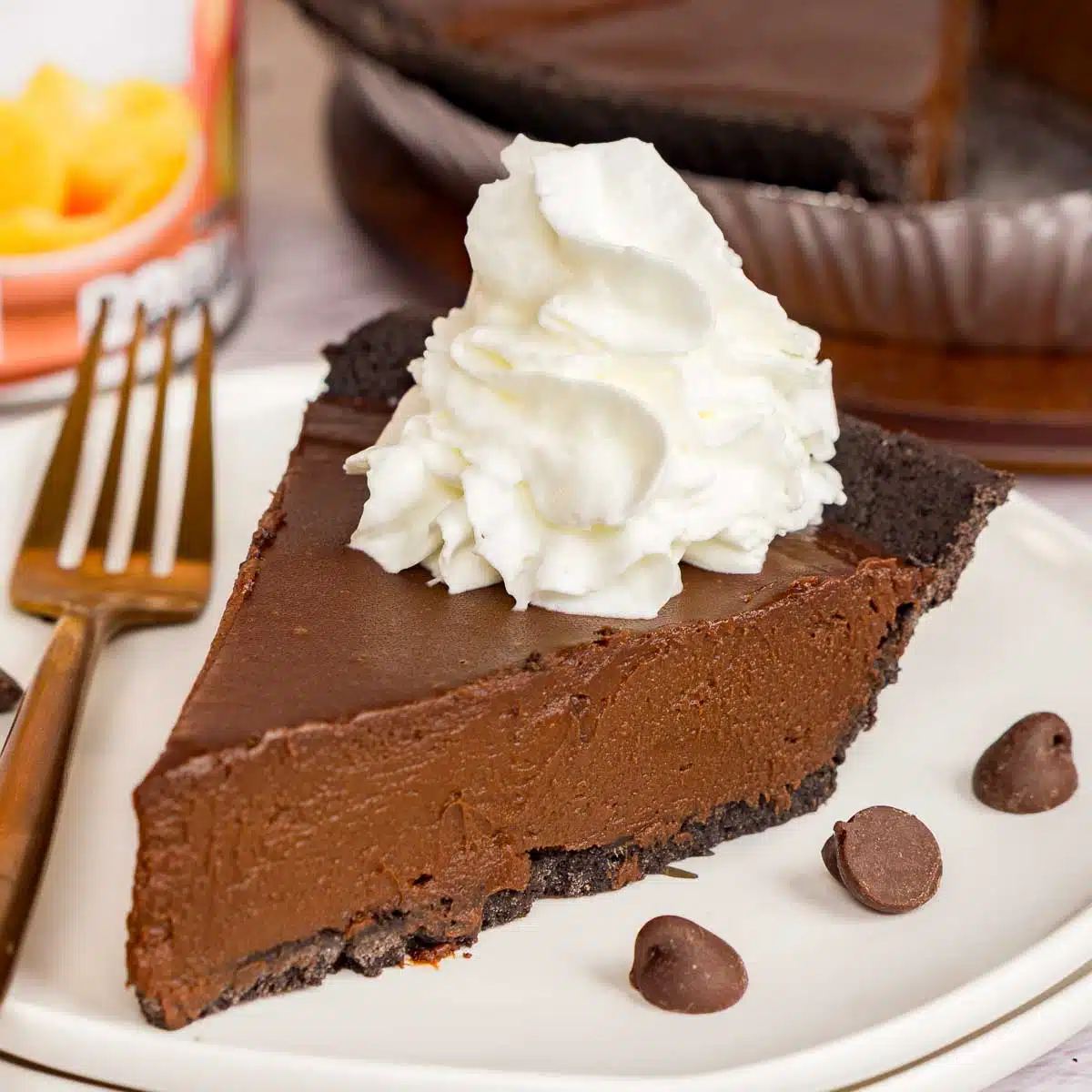 Slice of a no bake chocolate mousse pie topped with whipped cream