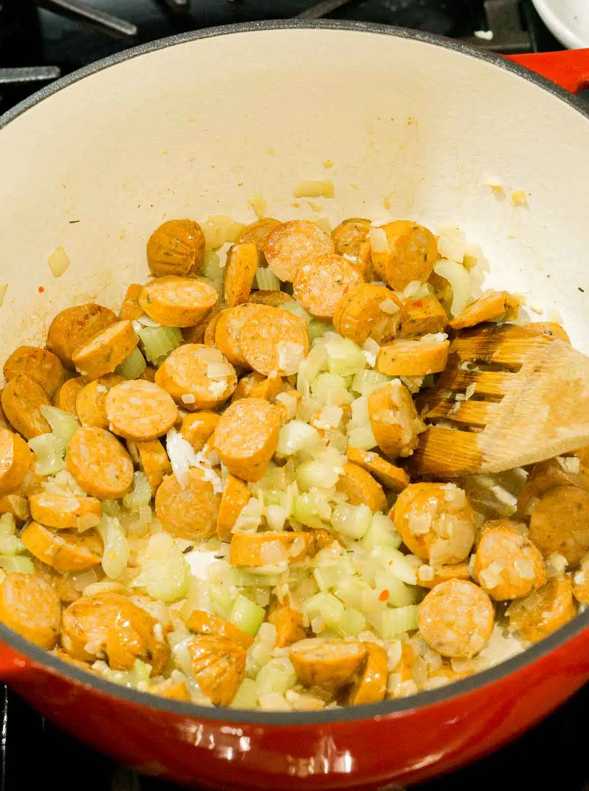 Andouille sausage, onion, celery in a soup pot