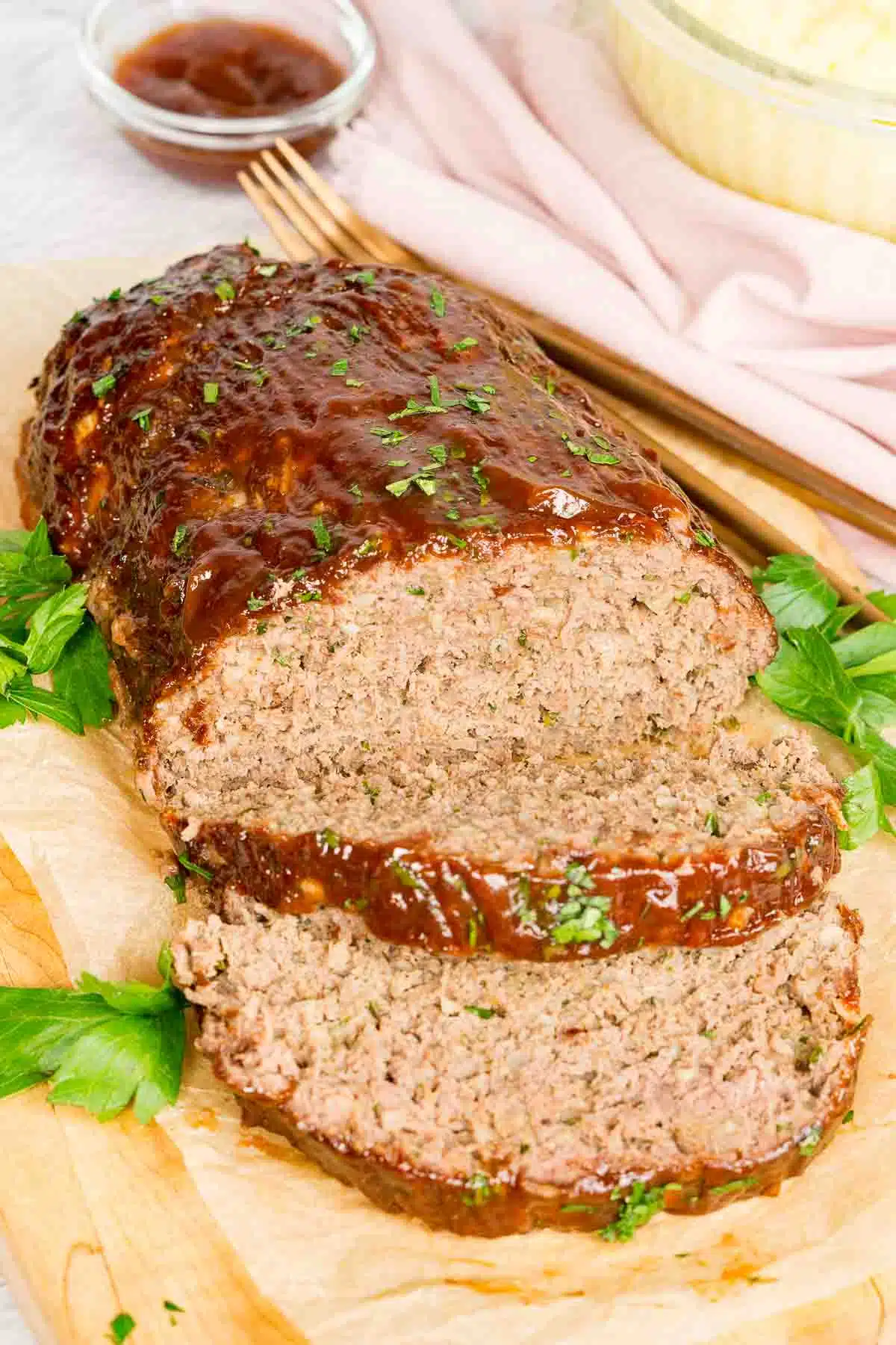 Sliced venison meatloaf with glaze on a cutting board