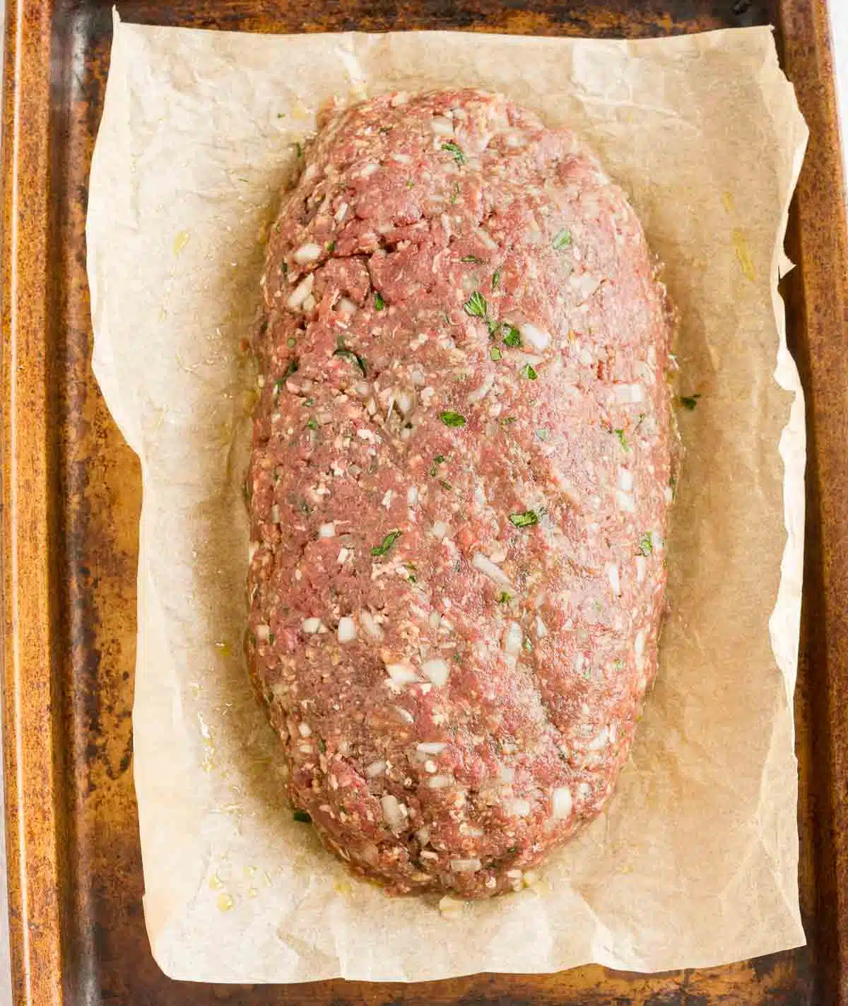 Venison meatloaf shaped on a pan, ready to bake