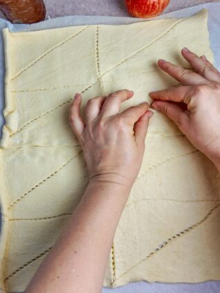 Pinching crescent roll dough together to make one large rectangle