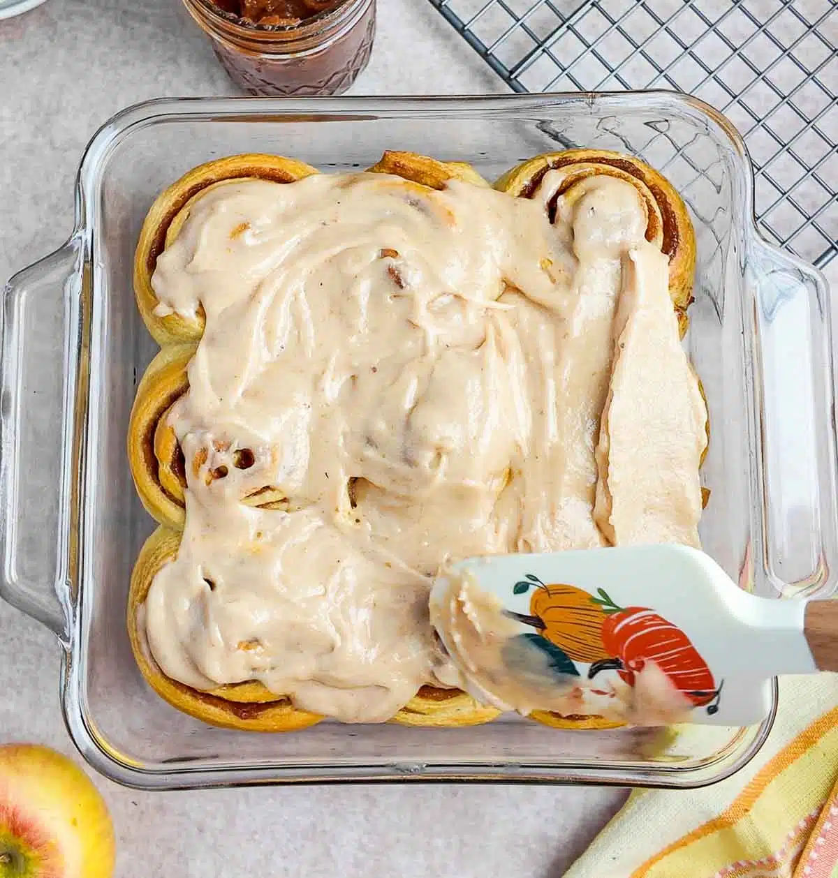 Spreading apple butter icing on apple butter rolls